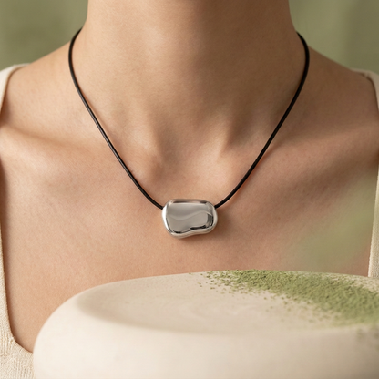 Collar Sienna plateado puesto con fondo aesthetic crema y verde matcha.